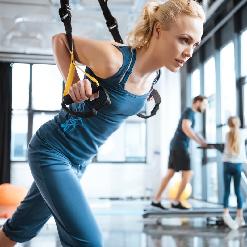blonde-fitness-woman-training-with-trx-fitness-straps